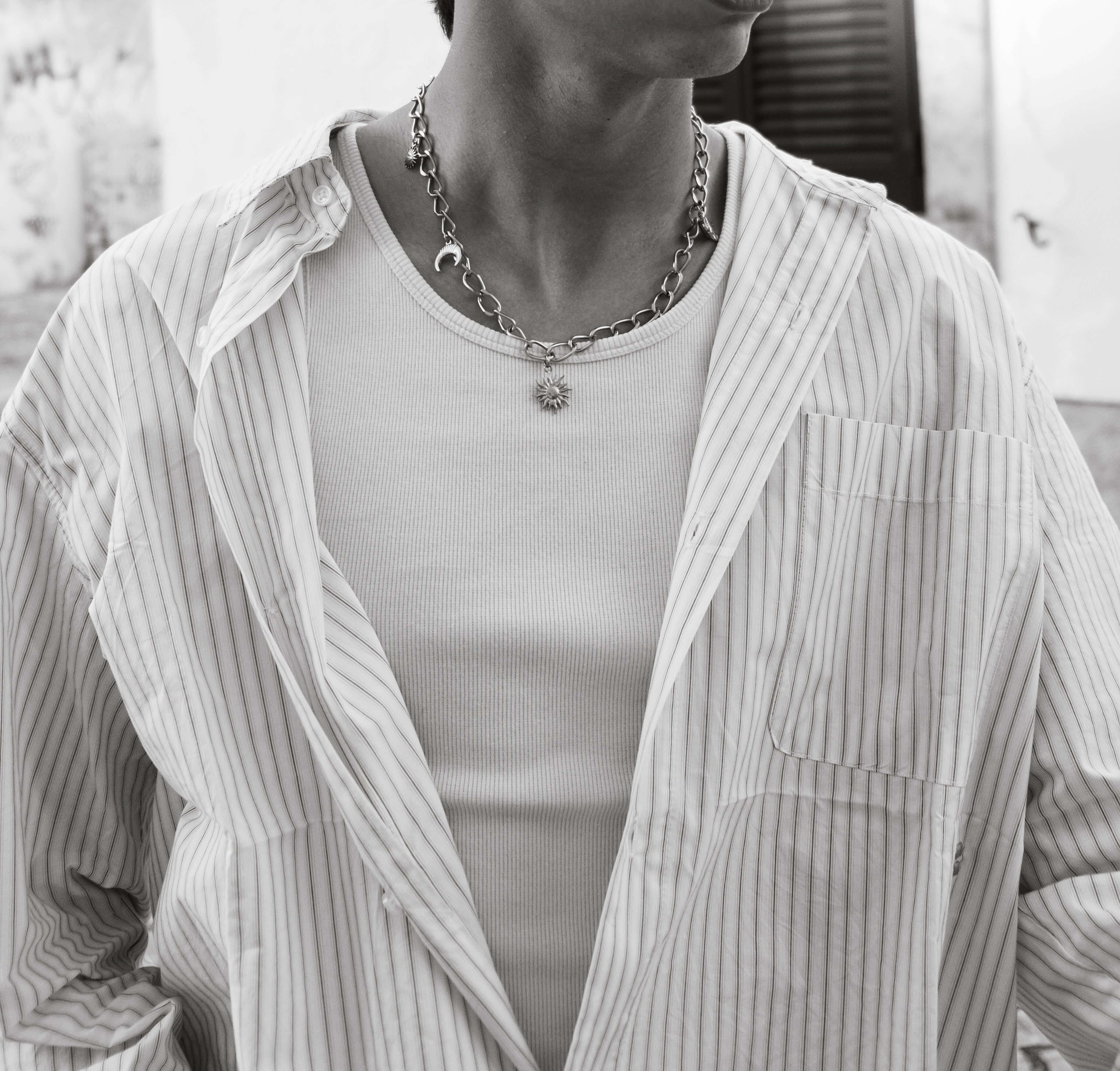 Close-up de um homem a usar um colar elegante da coleção Colares, destacando o design único e a confiança.