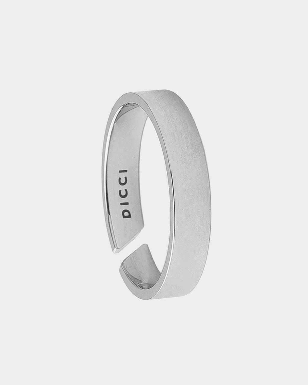 A minimalist silver-toned open band ring with a brushed finish and the brand name 'DICCI' engraved inside, shown on a light gray background.