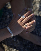 Sunray silver ring worn by model on a neutral background