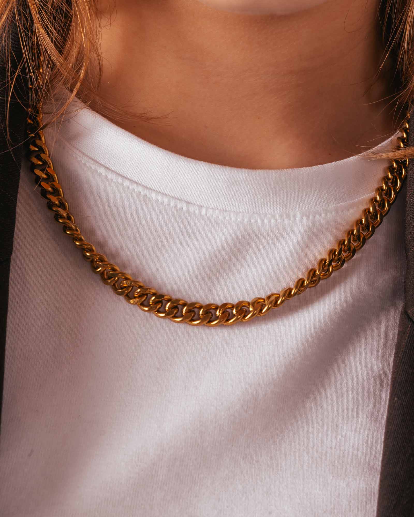 Gold chain necklace on a white shirt
