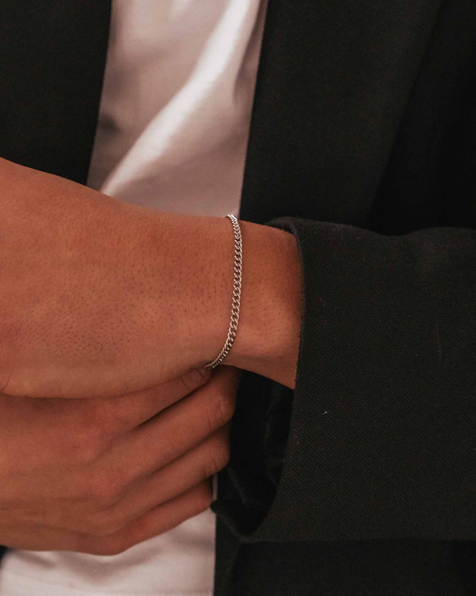 Silver curb cuban chain bracelet on wrist