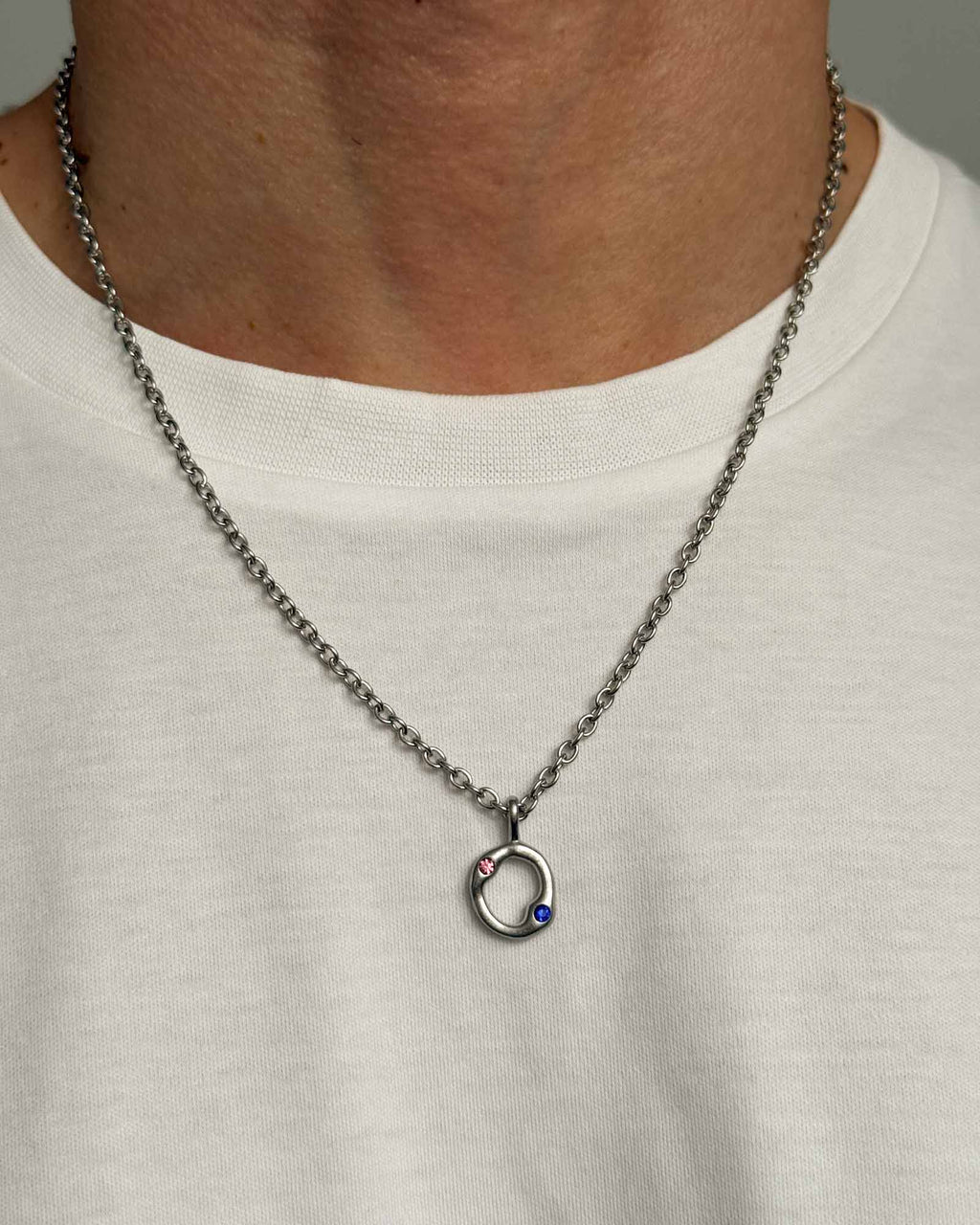 Necklace with a pendant worn by a person on a plain background