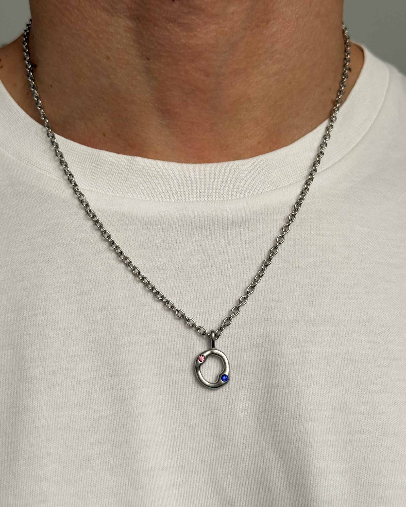 Necklace with a pendant worn by a person on a plain background
