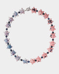 A beaded necklace featuring alternating star-shaped beads in pink, blue, and white, separated by small dark round beads, on a light gray background.
