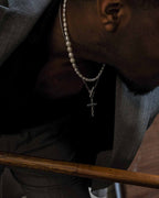 Twisted cross pendant in stainless steel worn by model