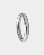 Un anello a fascia minimalista in argento lucido con il nome del marchio "DICCI" inciso all'interno, mostrato su uno sfondo grigio chiaro.