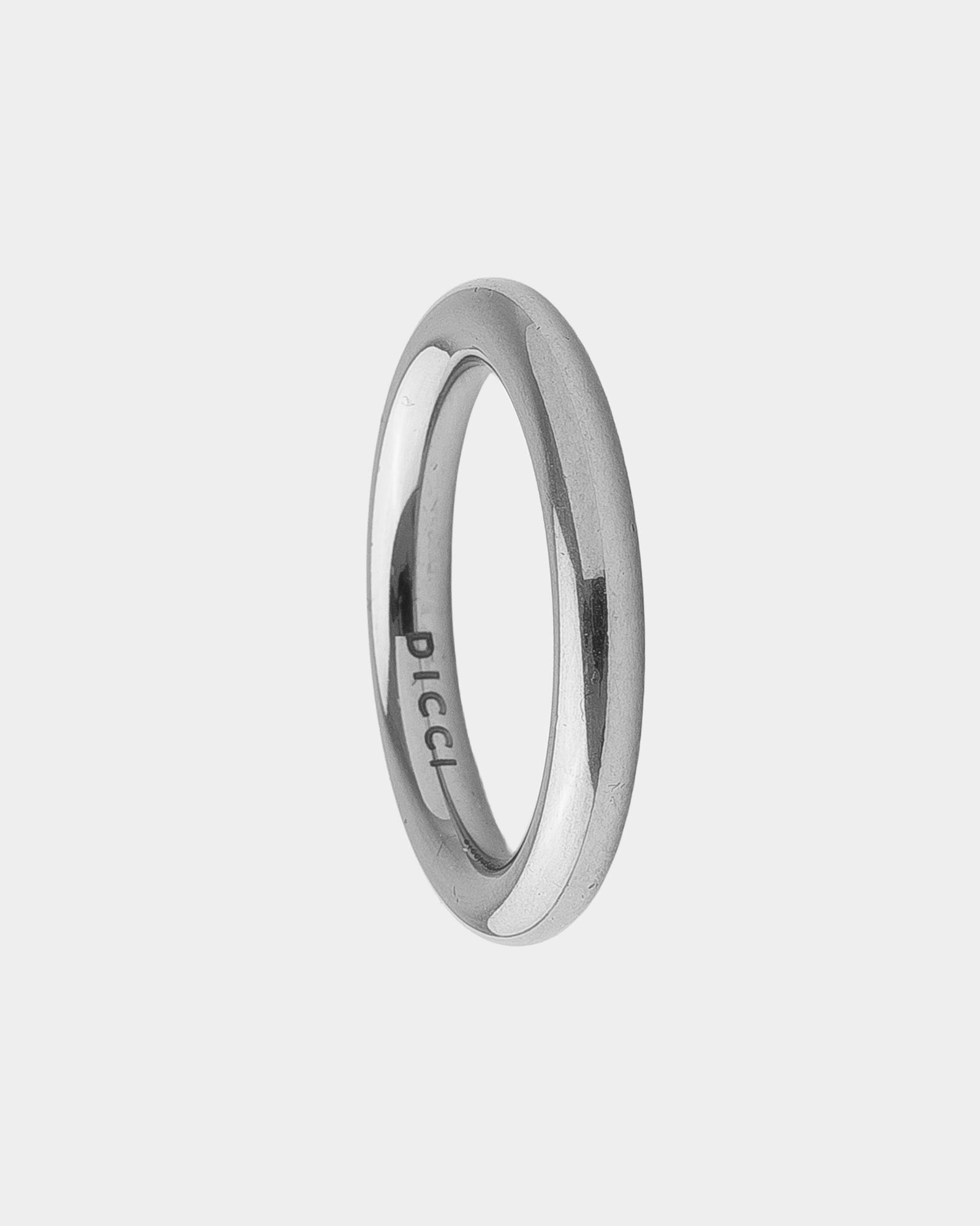 A minimalist polished silver band ring with the brand name 'DICCI' engraved on the inside, shown on a light gray background.