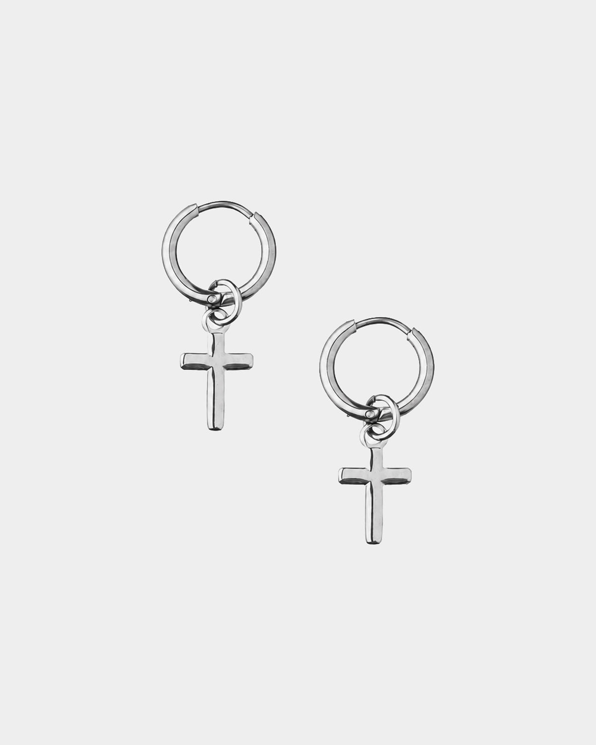 A pair of silver hoop earrings with small cross charms, displayed on a light gray background.