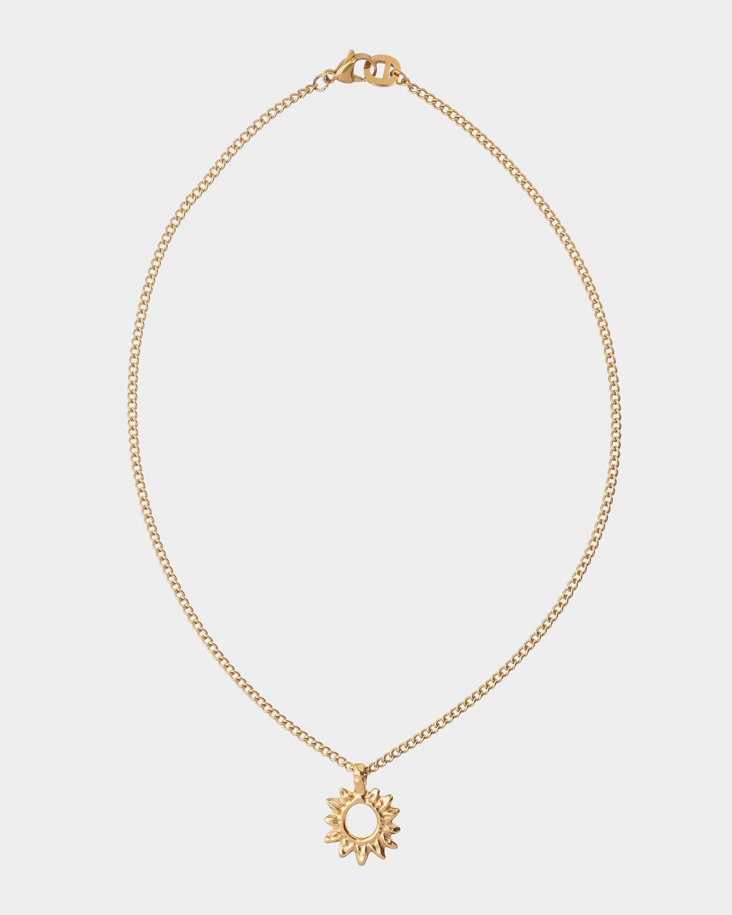 Gold necklace with a sun pendant on a light gray background