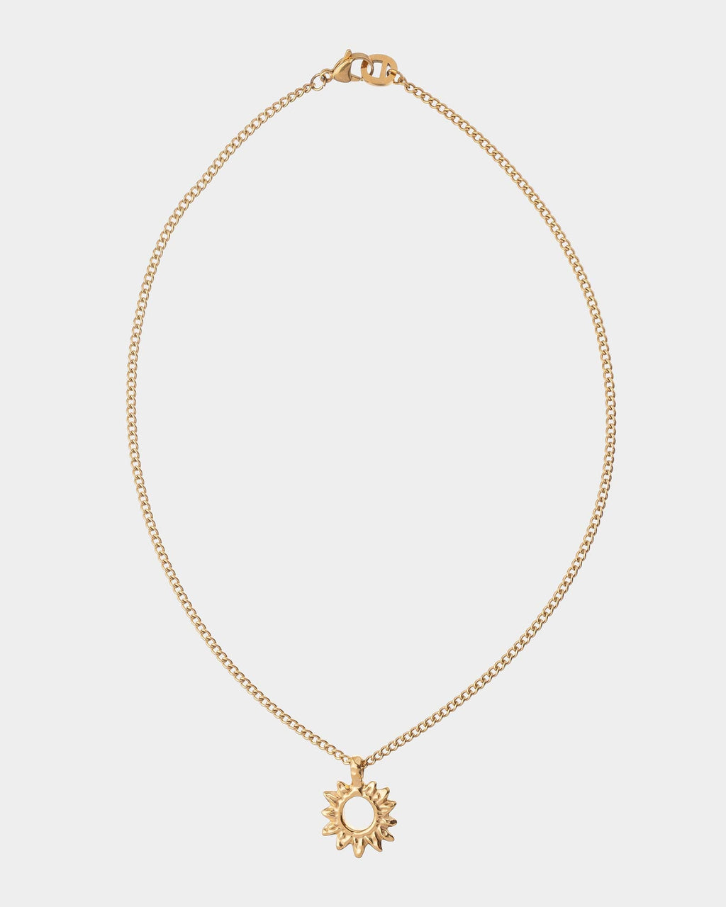 Golden necklace with a sun pendant on a light gray background