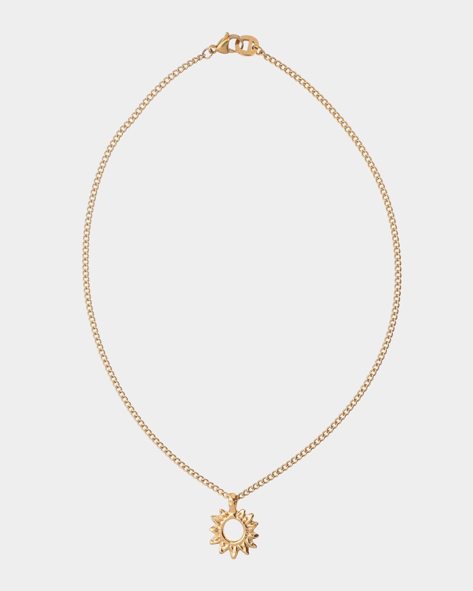Golden necklace with a sun pendant on a light gray background