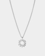 Silver necklace with a sun-shaped pendant on a light gray background