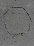 Silver chain necklace with a unique clasp on a gray concrete surface