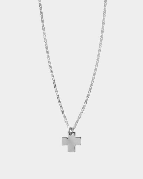 Silver cross necklace on a light gray background
