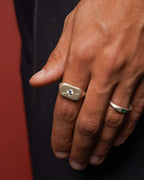 Close-up of a hand wearing two silver rings with gemstones from DIcci