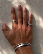 Hombre con el anillo Flat Emerald plateado y pulseras