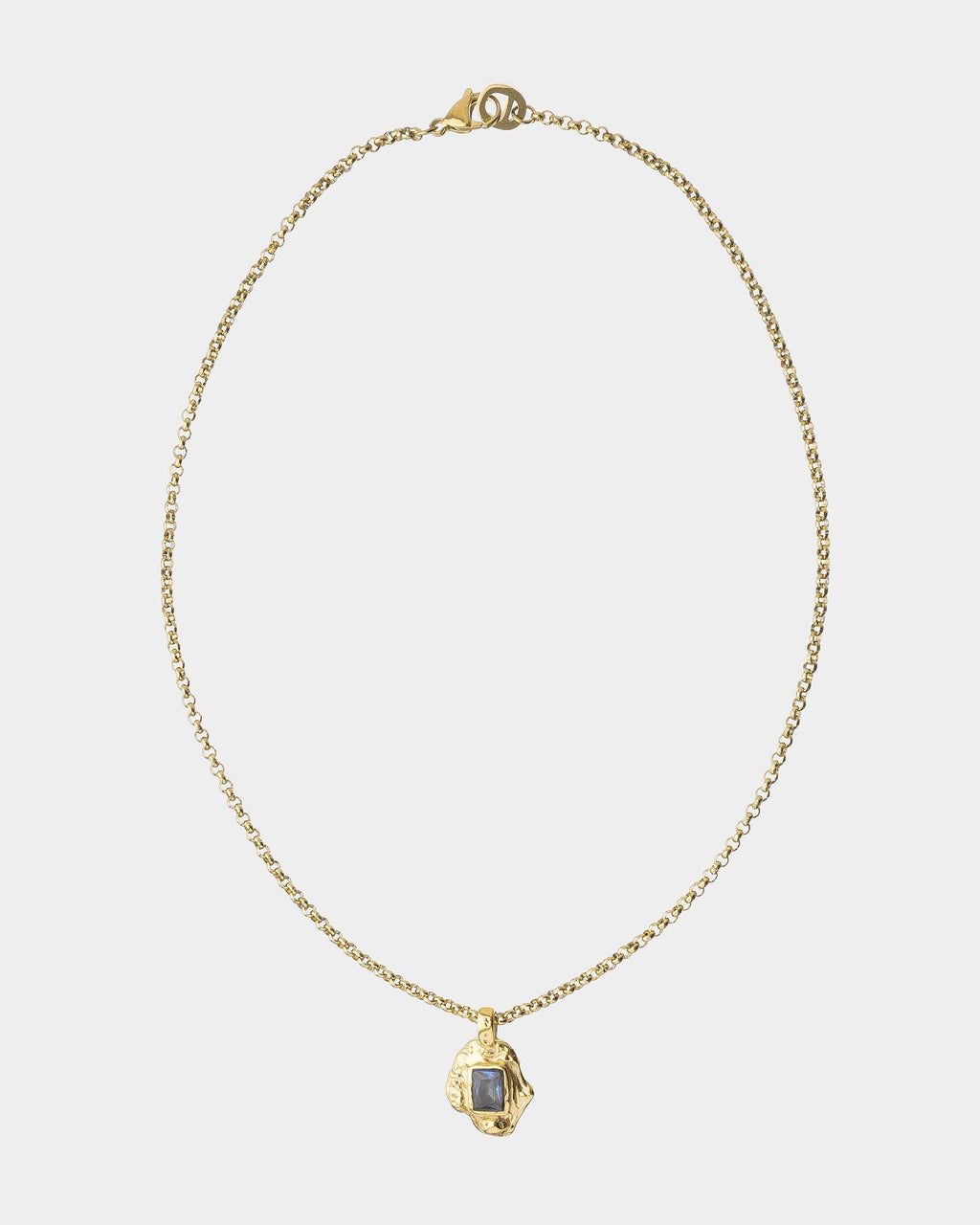 Gold necklace with a pendant on a light gray background