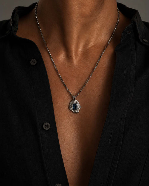 man wearing necklace with blue stone