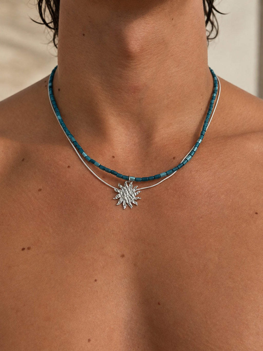 men wearing helios necklace