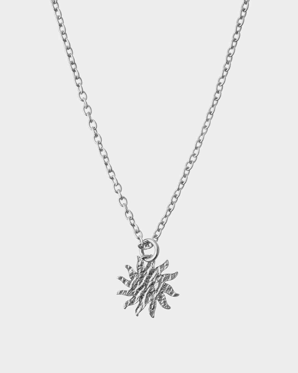 Silver necklace with a star-shaped pendant on a light gray background