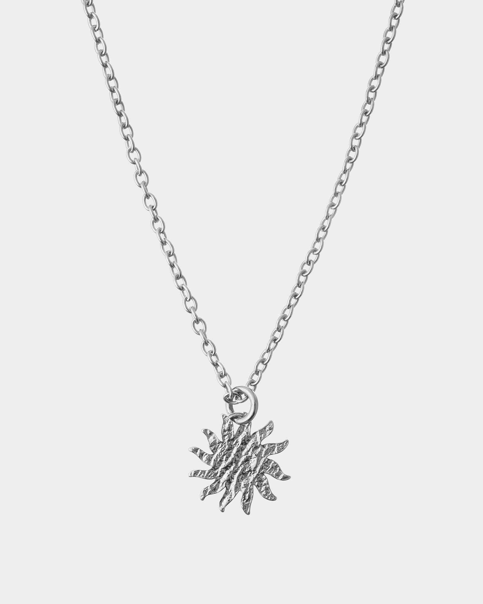 Silver necklace with a star-shaped pendant on a light gray background