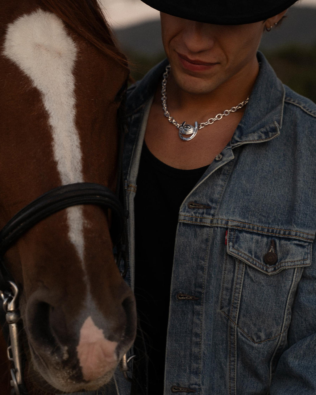 man wearing horseshoe necklace