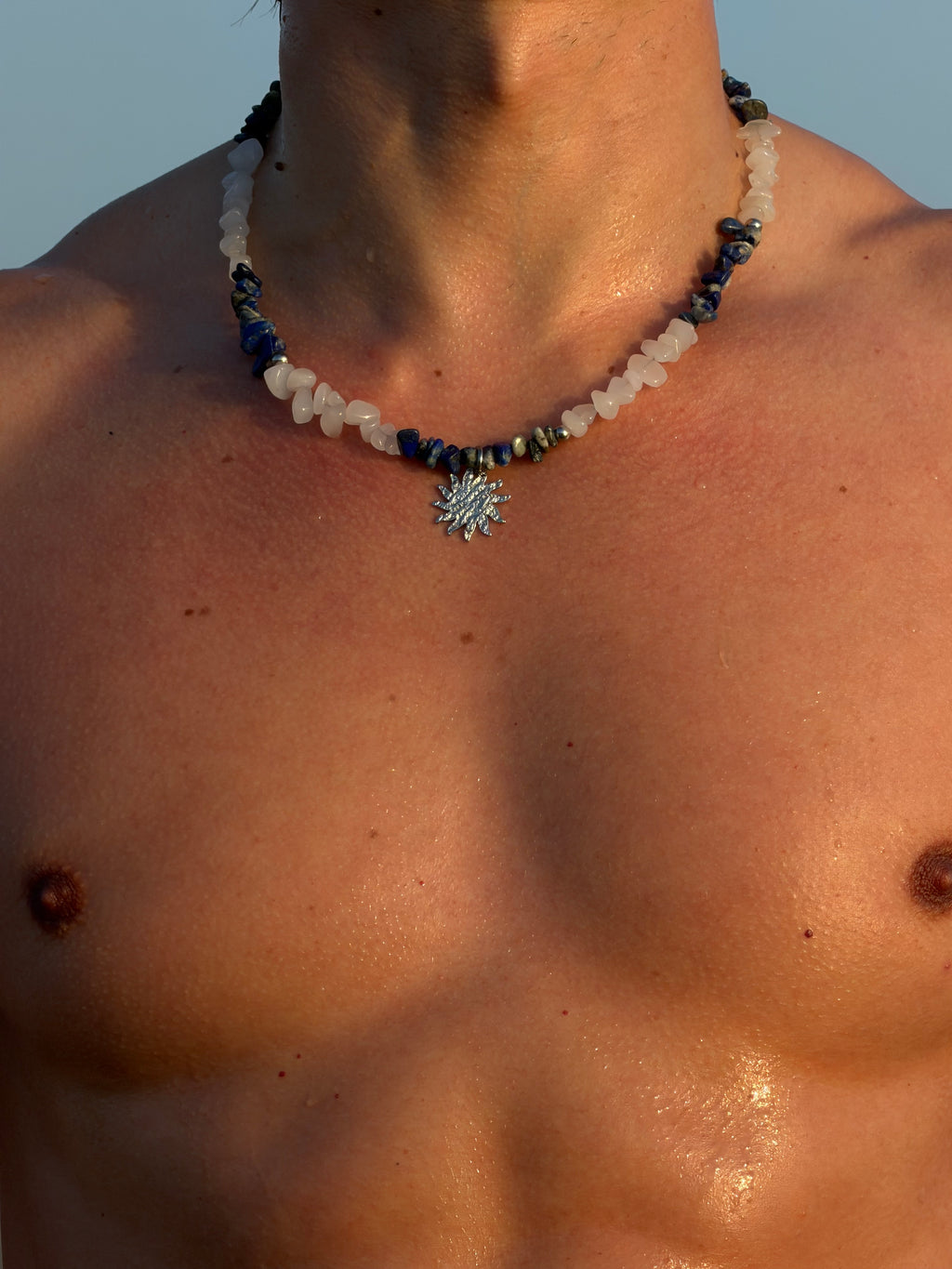 man wearing marea sun necklace