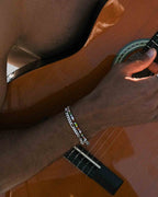 Figaro 5x1 silver bracelet worn on wrist on a neutral background