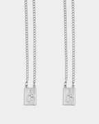Silver - Two silver chain necklaces with rectangular pendants featuring an embossed figure, displayed against a light gray background.