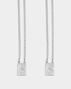 Silver - Two silver chain necklaces with rectangular pendants featuring an embossed figure, displayed against a light gray background.