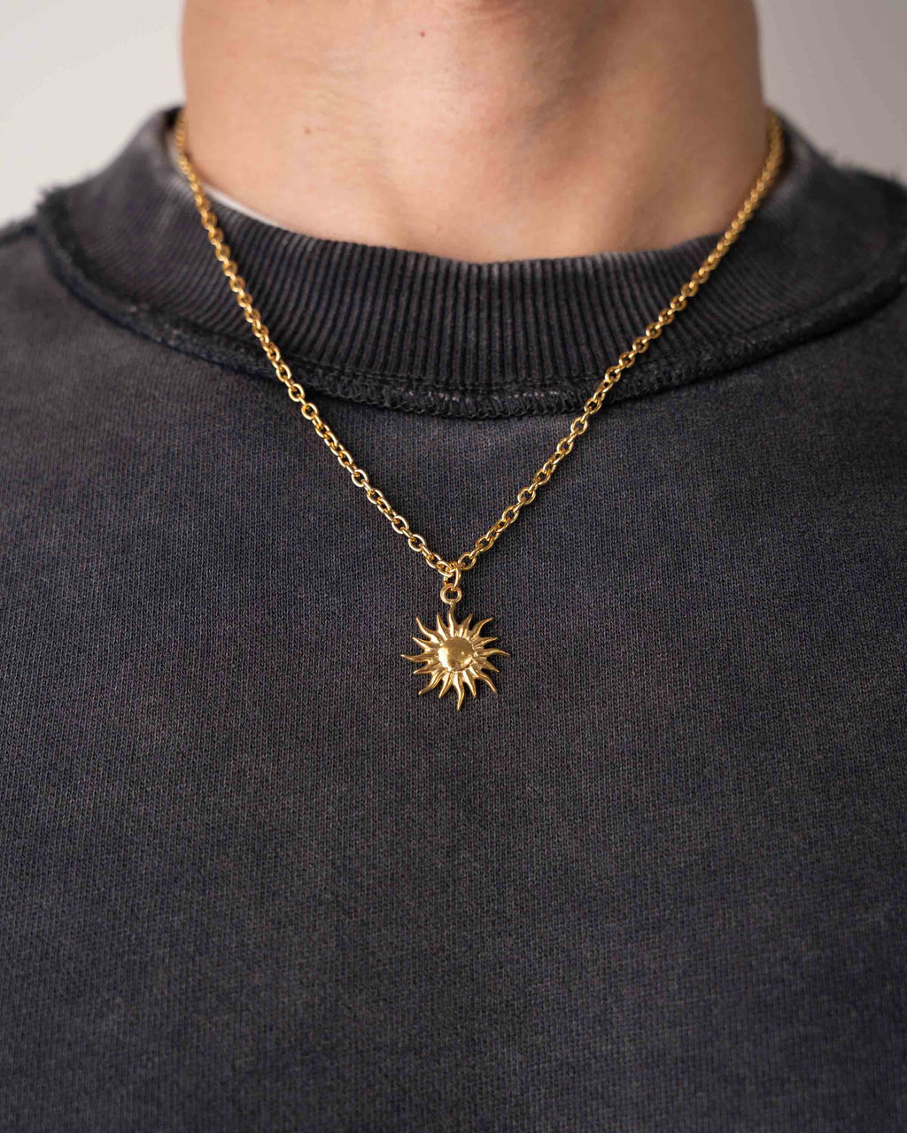 Gold sun chaser necklace in stainless steel worn by model