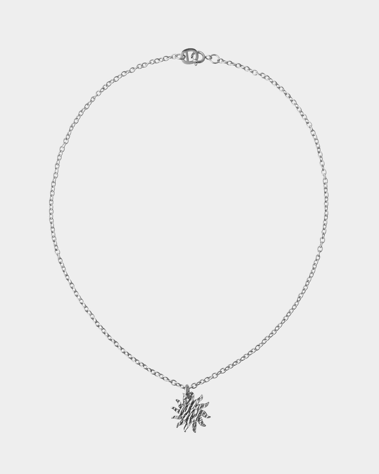 Silver necklace with a snowflake pendant on a light gray background