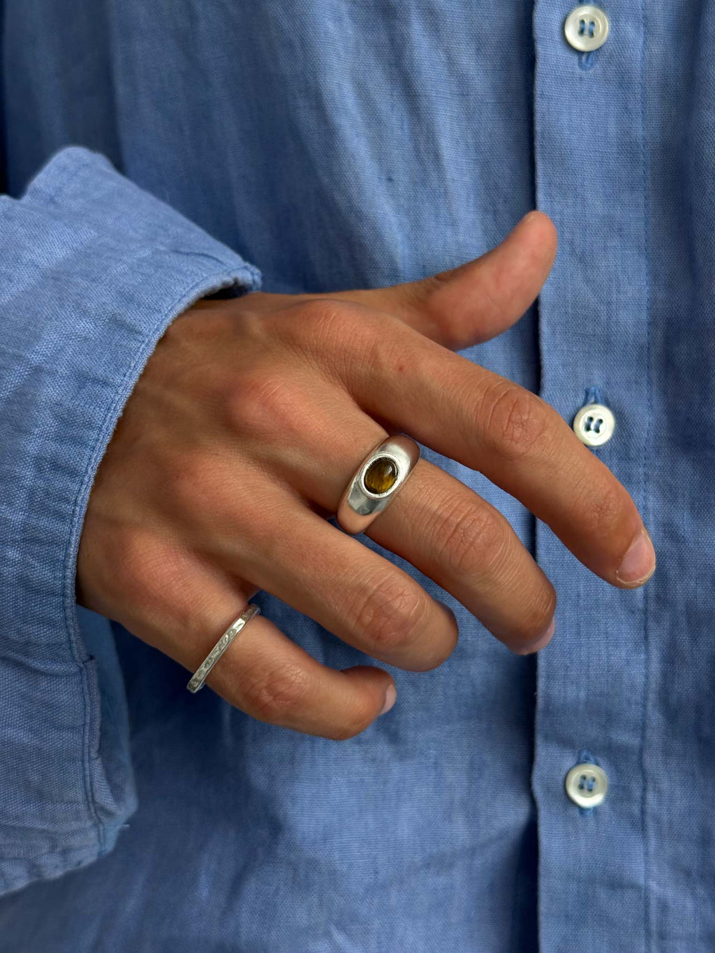 Tiger-eye stone ring on finger