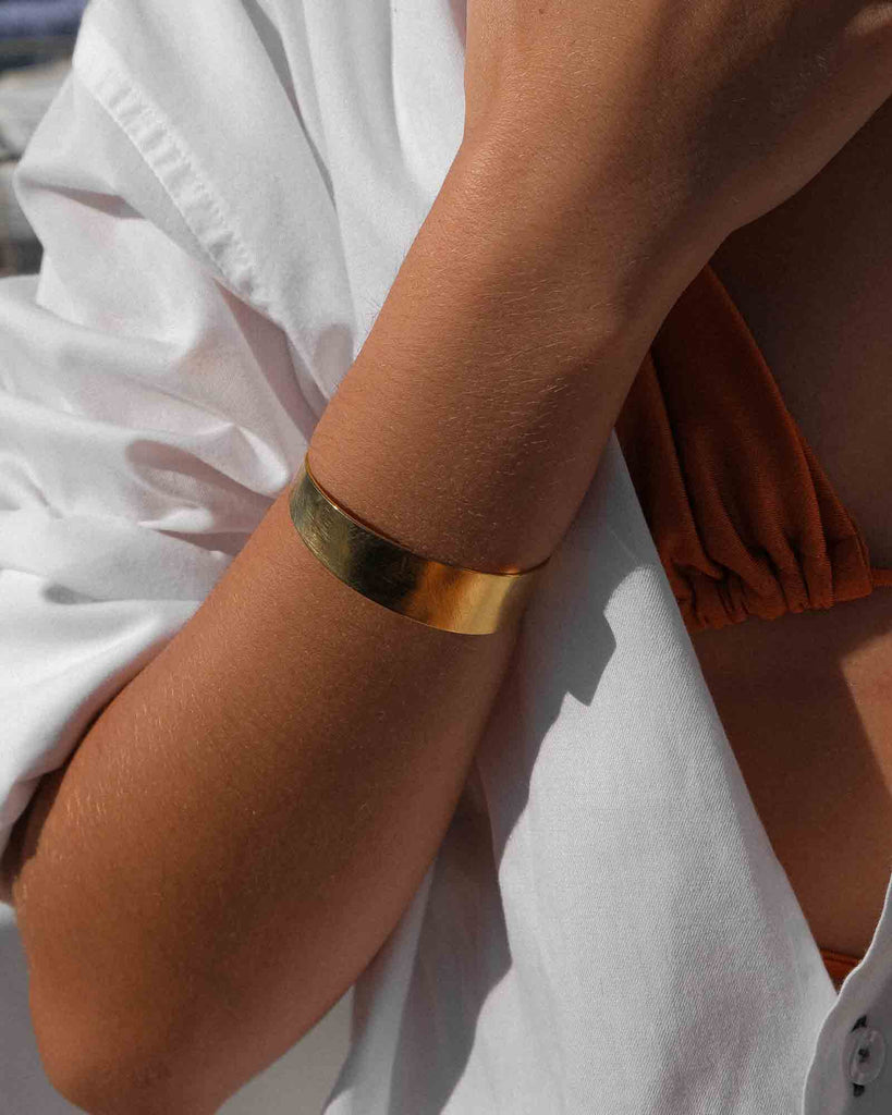 woman using golden bracelet cuff