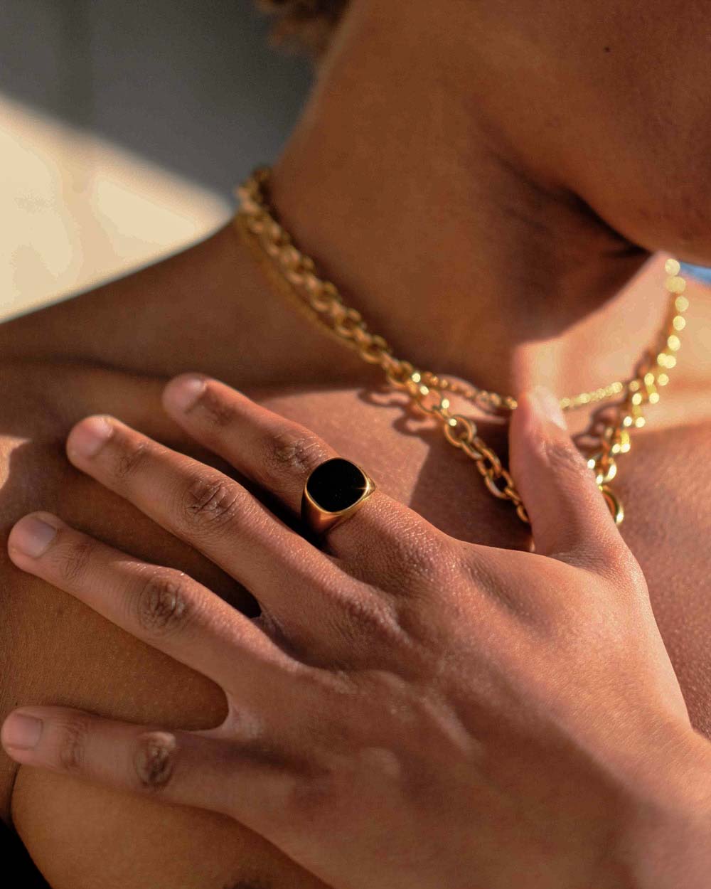 Anello in acciaio dorato con pietra nera sul dito del modello - Anelli in acciaio inossidabile - Acquista anelli online - Gioielli Unisex Online - Dicci
