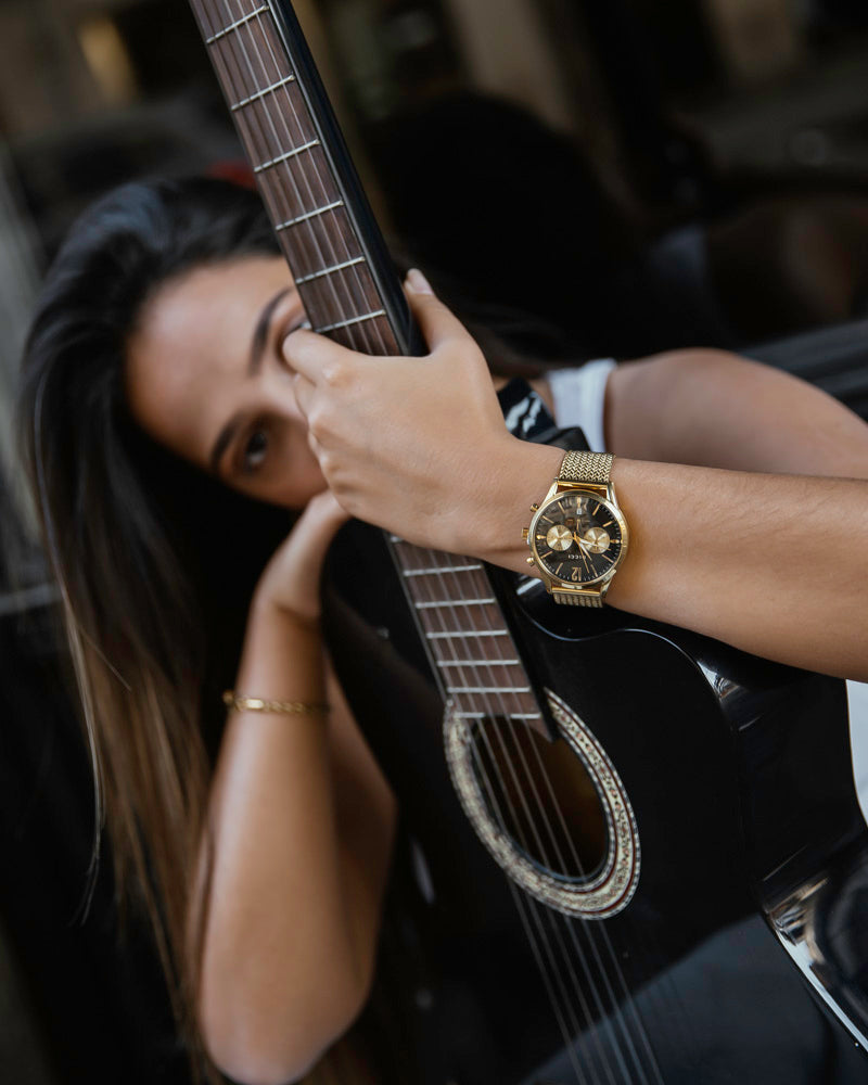 Chronometer - Relógio c/ mostrador preto com bracelete dourada no pulso da modelo - Joias Online - Dicci