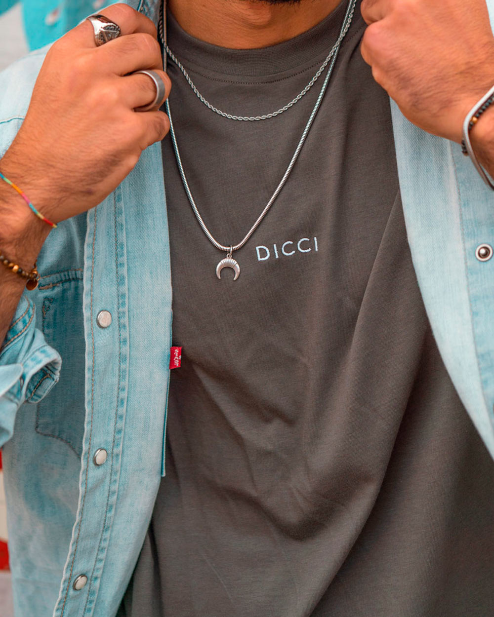 Silver stainless steel rope chain necklace worn over gray t-shirt with denim jacket