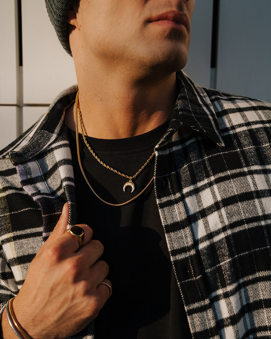 Horns - Cadena trenzada de acero dorado en el cuello del modelo - cadena de acero inoxidable Raso y un colgante de un cuerno - Joyería Unisexo Online - Dicci