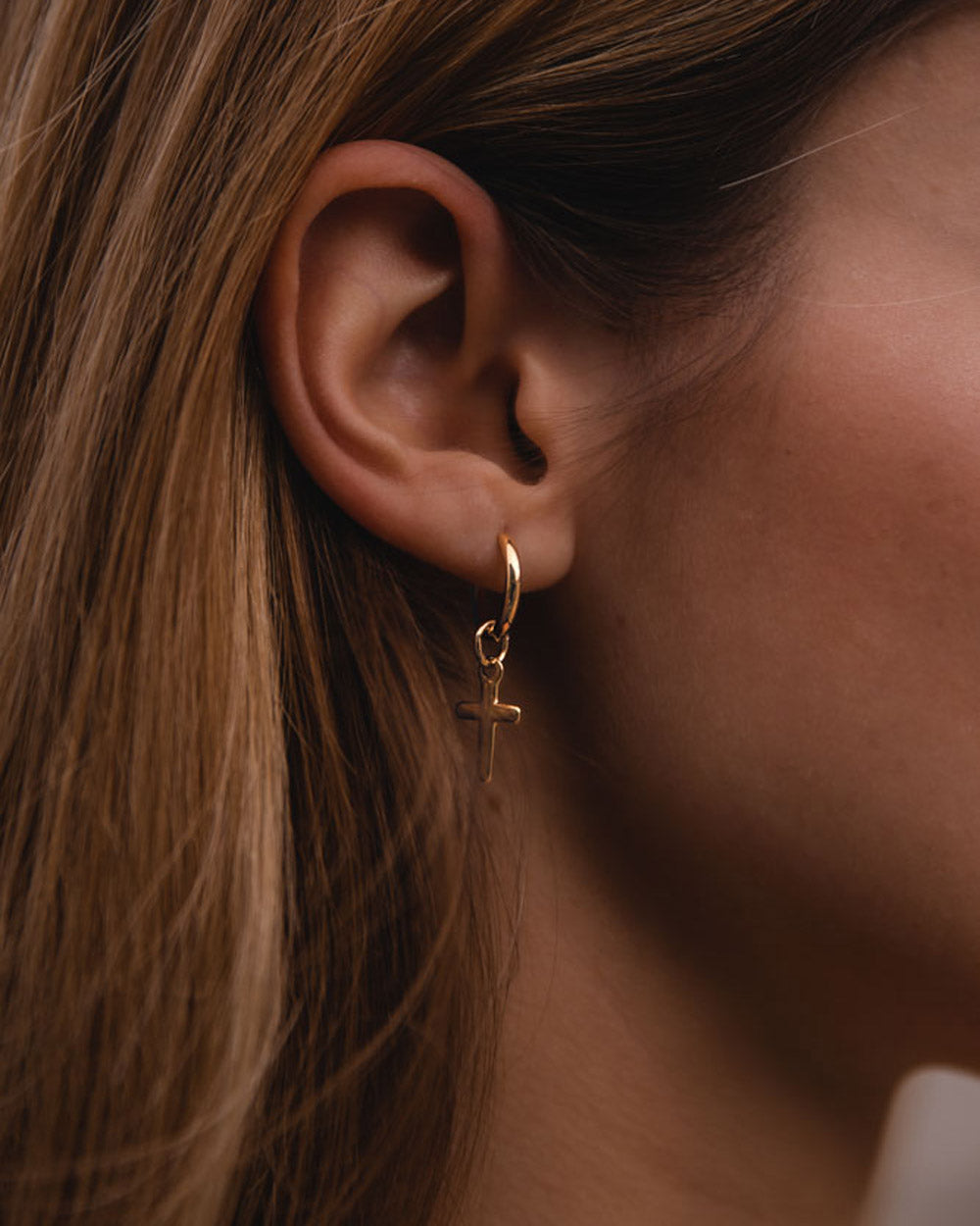 Santa Cruz - Pendiente de acero dorado en la oreja del modelo - pendientes de acero - joyería unisexo online - dicci