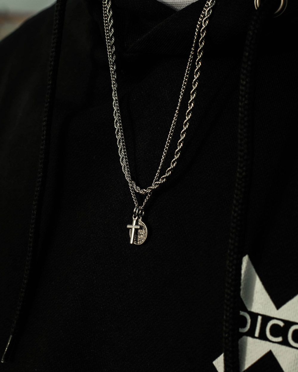 Silver stainless steel rope chain necklace with pendants on black hoodie